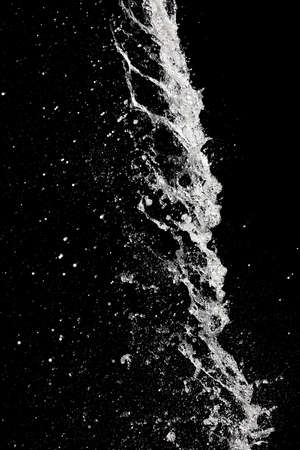 Splash of pouring water isolated over black backgroundの写真素材