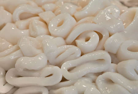 Close-up of a stack of fresh calamari rings in a market