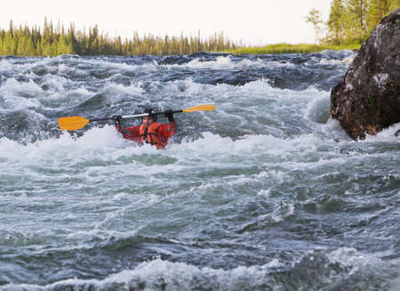 Kayaker turning over in the cataract whitewater
