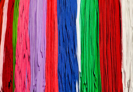 Many colorful shoestrings hanging on a rack