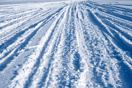 Many ski and car tracks on snowの写真素材