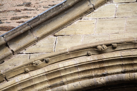 Intricate stone hands on an old structure in Conques, France, showcase remarkable medieval craftsmanship.の写真素材