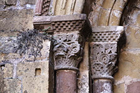 Elaborate stone columns with detailed carvings highlight the rich history and artistry found in Conques, France.の写真素材