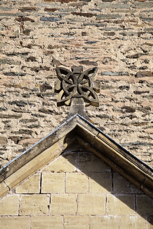 Unique stone sculpture adorns the gabled roof of a historic structure in Conques, showing exquisite craftsmanship.の写真素材