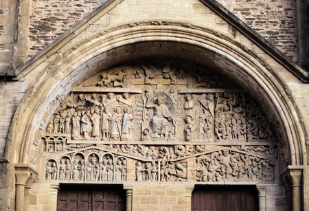 Detailed stone sculptures at the church entrance in Conques highlight medieval craftsmanship and artistic expression.の写真素材