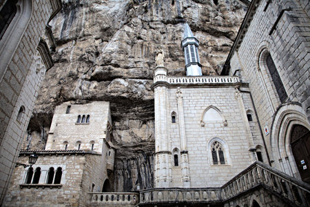 Rocamadour showcases stunning cliffside architecture amid lush greenery and dramatic skies, rich in history.の写真素材