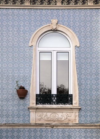 A beautifully designed window adorns the facade of a house in Alcobaca, Portugalの写真素材