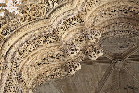Detailed Gothic architecture of Batalha Monastery's Unfinished Chapels under a clear blue skyの写真素材