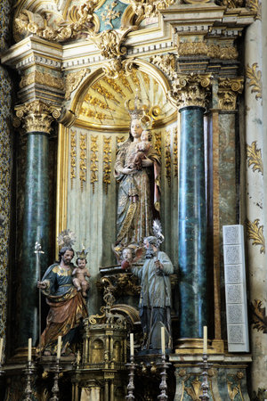 Coimbra, Portugal - April 3, 2017 - Visitors explore the chapel of Sao Miguel inside Coimbra University, admiring the ornate baroque architecture and vivid art detailsの写真素材