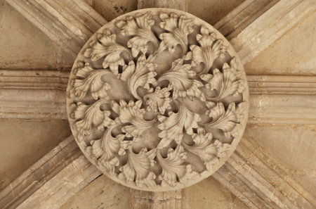 Decorative stone work adorns the ceiling above visitors at Batalha monastery in Portugal during a...
