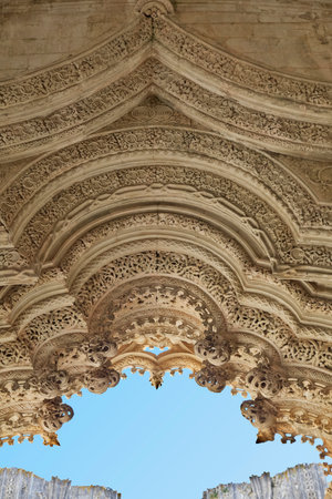 Detailed stone archway displays intricate patterns at Batalha monastery in Portugal showcasing...