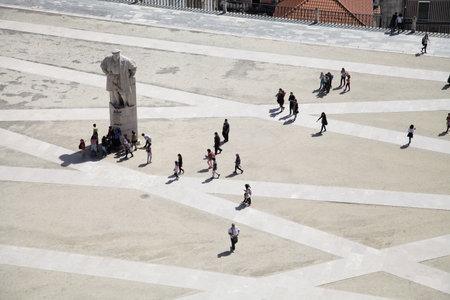 Coimbra, Portugal - April 3, 2017 - Crowds stroll leisurely through the plaza in Coimbra, engaging with the statue of Joao IIIの写真素材