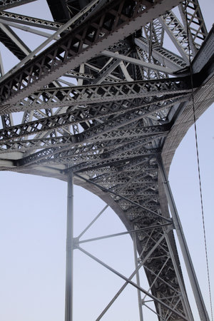 Beneath theDom Luis I Bridge in Porto, Portugal, steel structures create a striking visual against...