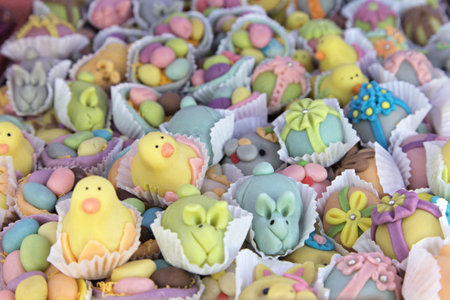 Sweet treats shaped like bunnies and chicks fill small cups, celebrating Easter festivities