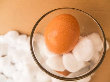 egg and Cotton bales in glass on brown paper backgroundの写真素材