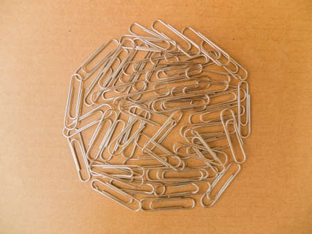 Paperclips on brown Background to keep sheets of paper together.の写真素材