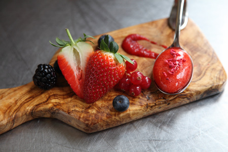 A spoon of strawberry soup with berries の写真素材