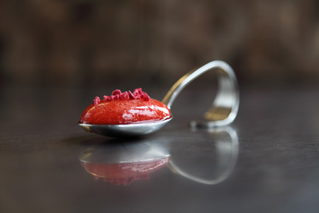 A spoon of strawberry soup with berries の写真素材