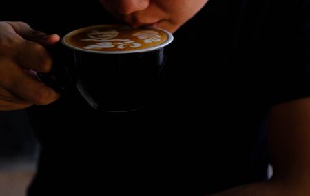 Hand Hold a Cup of Coffee. Menu Drink for Relax on Wood Table Texture and Space for your text....