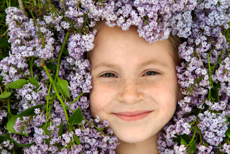 Smiling young girl face surrounded by purple Lilacsの写真素材