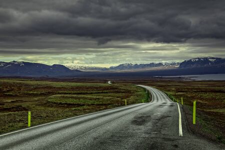 Empty road to mountains in a remote part of Iceland.の写真素材