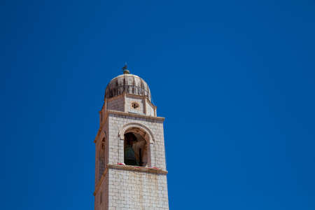 Dubrovnik, Croatia - July 11, 2019: The bell tower of the Franciscan Monastery in Dubrovnik's Old Town against a clear blue sky.のeditorial素材