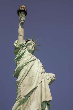 New York City, NY - September 28, 2009: The iconic Statue of Liberty isolated against a clear blue...