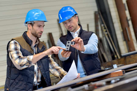 Engineer with mechanical worker checking on production Engineer with mechanical worker checking on production