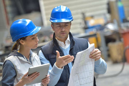 Engineers in mechanical factory reading instructions Engineers in mechanical factory reading instructions