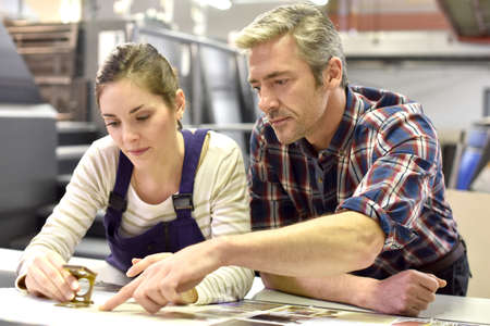 Man working with apprentice in printing house Man working with apprentice in printing house