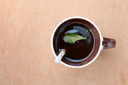 coffee Mug with a spoon and leaf on top view, relax conceptの写真素材