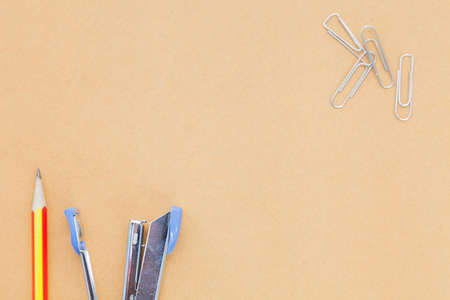 pencil staple and clip placed on brown paper