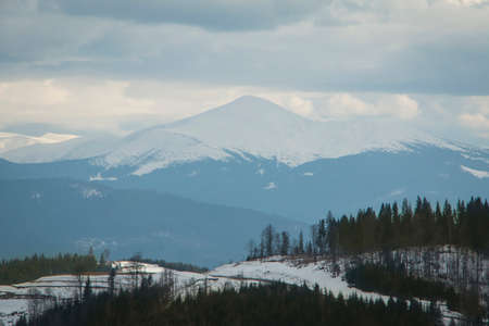 High snowy mountain in foggy weather and cloudsの写真素材