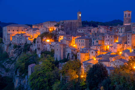 Italy. The old town of Pitigliano. Late summer evening. Stone walls and street lightsの写真素材