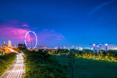 Evening Singapore. Road traffic, Super-Trees in Gardens by the Bay and lightning above the Singapore Flyerのeditorial素材