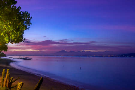 Indonesia. Coast of the bay between the islands after sunset. Boats and lights of the other shoreの写真素材