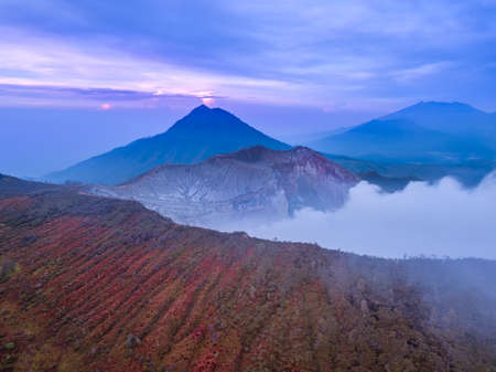 Indonesia. Bali Island. Early morning at the active volcano Ijen. Slope with tropical vegetation and...