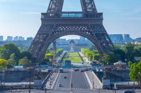 France, Paris. Eiffel Tower and Champ de Mars. Few tourists and cars in the summer sunny morning