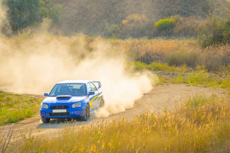 Summer sunny day. Rally car is turning the dirt road. A lot of dustのeditorial素材