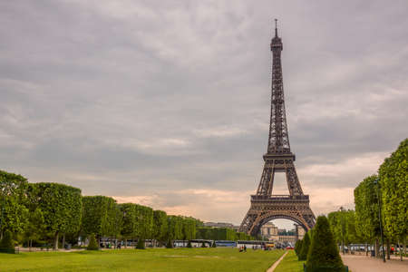 France. Paris. Cloudy summer day. Champ de Mars and the Eiffel Tower. Many tourists and buses
