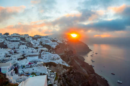 Greece. Santorini island. White houses in Oia on the island of Santorini. Yachts and catamarans in the anchorage. Sunriseの写真素材