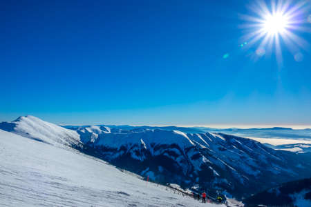 Winter Slovakia. Ski resort Jasna. View from the top of the snow-capped mountains and ski slope with skiersの写真素材