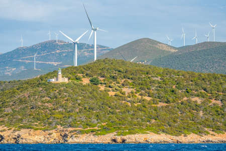 Greece. Hilly coast of the Gulf of Corinth in sunny weather. Old lighthouse building and many wind farmsの写真素材