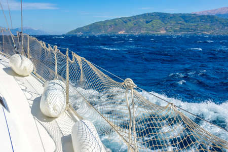Sunny summer day. Windy weather near the shore of the Gulf of Corinth. Deck of a white sailing yacht with fendersの写真素材