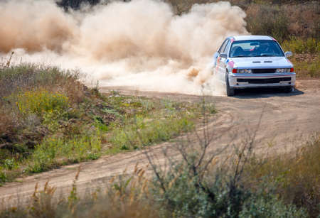Summer dry dirt road. Sunny day. Lot of dust on a sharp bend from a rally carの写真素材