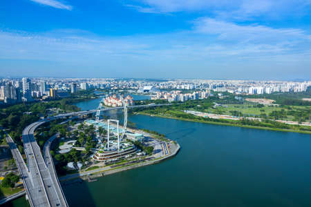 Singapore. Sunny day. Panorama of residential areas, Ferris wheel and highway. Aerial view