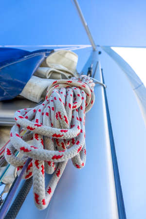 Bottom view of the mast of a sailing yacht. A hank of rope and other rigging. Blue skyの写真素材
