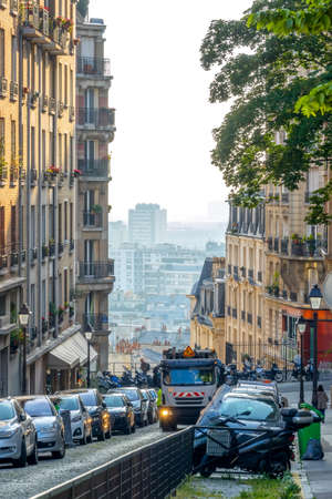 France. Sunny summer day in Paris. Lots of parked cars on the narrow Lamarck streetのeditorial素材