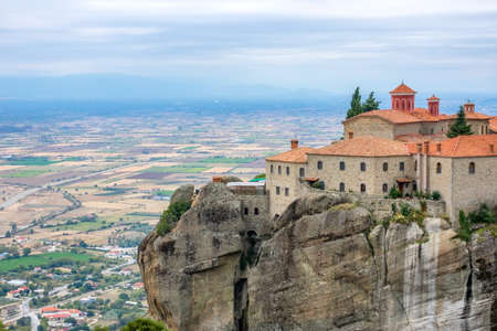 Greece. Summer day in Meteora. Monastery on a high cliff above the town and fieldsのeditorial素材