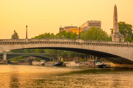 France, Paris. Summer evening over the bridges of the Seine. Residential barges are moored at the river bankの写真素材